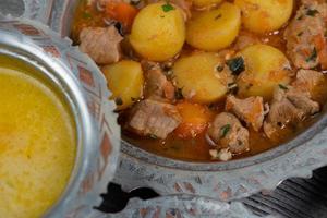 eid mubarak cena tradicional ramadán iftar. variada comida sabrosa en auténticos platos rústicos sobre fondo de mesa de madera. foto