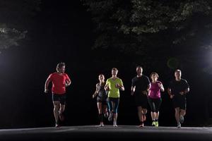 equipo de corredores en el entrenamiento nocturno foto