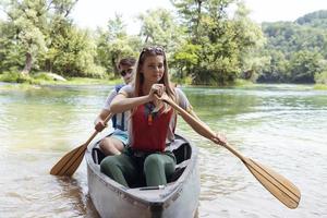 friends are canoeing in a wild river photo