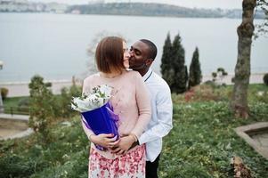 Happy multiethnic couple in love story. Relationships of african man and white european woman. photo