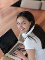 relaxed young woman at home working on laptop computer photo