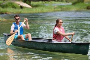 friends are canoeing in a wild river photo