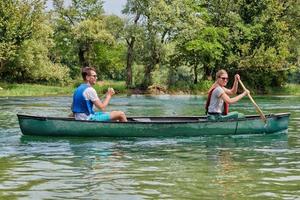 friends are canoeing in a wild river photo