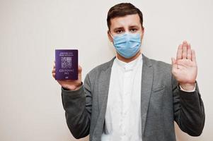 European man in formal wear and face mask, show Czech Republic passport with stop sign hand. Coronavirus lockdown in Europe country concept. photo