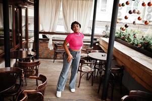 mujer afroamericana joven urbana en top rosa y jeans grises. mujeres afro moda chic. foto