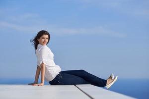 relaxed woman in front of luxury modern home photo