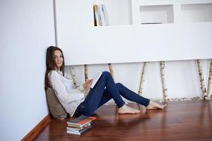 relaxed young woman at home working on laptop computer photo