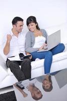 joyful couple relax and work on laptop computer at modern home photo