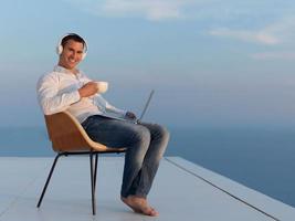 relaxed young man at home on balcony photo