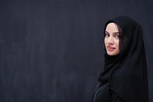 portrait of beautiful muslim woman in front of black chalkboard photo