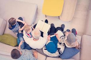 top view of modern muslim grandparents with grandchildren reading Quran photo