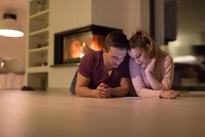 Young Couple using digital tablet on cold winter night photo