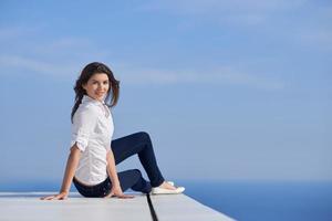 relaxed woman in front of luxury modern home photo