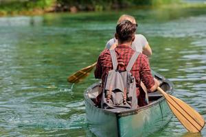 friends are canoeing in a wild river photo