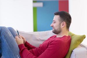 young man using a mobile phone  at home photo