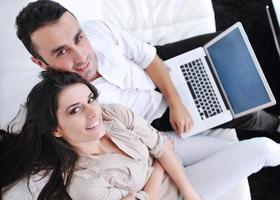 joyful couple relax and work on laptop computer at modern home photo