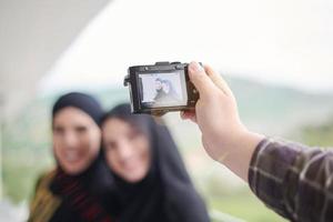 un hombre toma una foto de mujeres musulmanas con una cámara