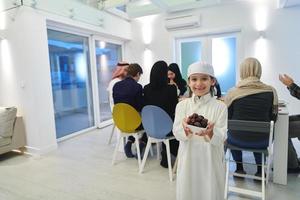 Arabian kid in the traditional clothes during iftar photo