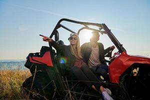 pareja disfrutando de un hermoso día soleado mientras conduce un buggy todoterreno foto