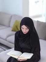 young muslim woman reading Quran at home photo