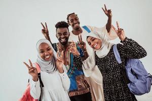 grupo de estudiantes africanos felices conversando y reuniéndose en equipo trabajando juntos en la tarea niñas vistiendo la moda tradicional de hiyab musulmán de sudán foto