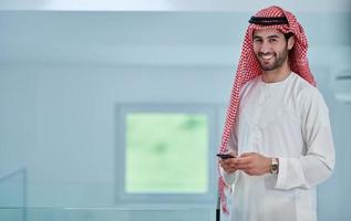 Portrait of young muslim businessman using mobile phone photo