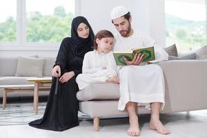 muslim family reading Quran and praying at home photo