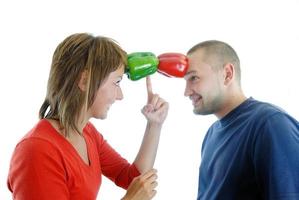 pareja feliz sosteniendo pimientos con la cabeza foto