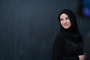 Modern young muslim woman in black abaya photo