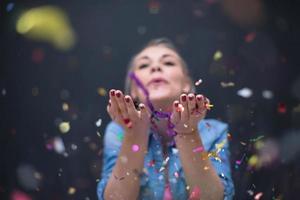 mujer soplando confeti en el aire foto