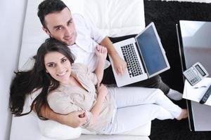 joyful couple relax and work on laptop computer at modern home photo