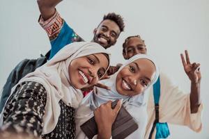 A group of multiethnic students take a selfie with a smartphone on a white background. Selective focus photo