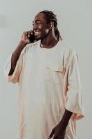 African man using smartphone and wearing traditional Sudan clothes. photo