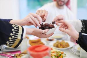 familia musulmana cenando iftar comiendo dátiles para romper la fiesta foto