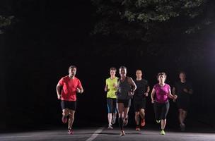 equipo de corredores en el entrenamiento nocturno foto