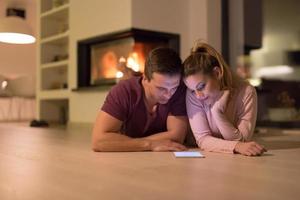 Young Couple using digital tablet on cold winter night photo