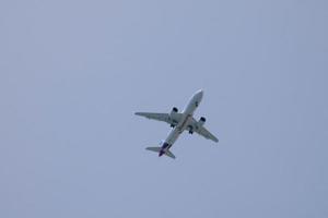 commercial aircraft flying under blue skies and arriving at the airport photo