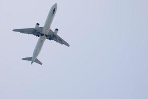 commercial aircraft flying under blue skies and arriving at the airport photo