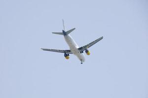 commercial aircraft flying under blue skies and arriving at the airport photo