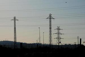 metallic electric towers supporting copper cables for transporting electricity photo