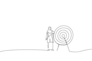 Cartoon of muslim business woman standing next to a huge target with a dart in the center, arrow in bullseye. Metaphor for reaching goals and objective. Continuous line art vector