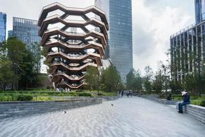 New York City, USA-August 7, 2019-Tourists admire and stroll near the architectural structure called Vessel in Manhattan during a cloudy day photo