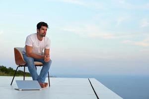 relaxed young man at home on balcony photo