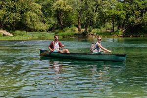 friends are canoeing in a wild river photo