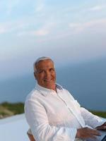 relaxed senior man on balcony photo