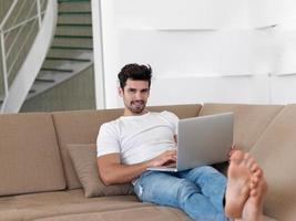 Man Relaxing On Sofa With Laptop photo
