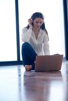 relaxed young woman at home working on laptop computer photo