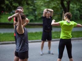 runners team warming up and stretching before morning training photo