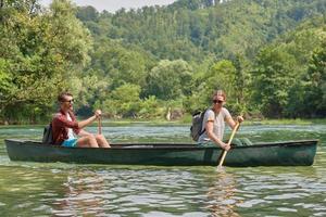 friends are canoeing in a wild river photo