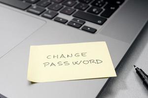 Change password message on sticky note on laptop. Computer security management concept photo